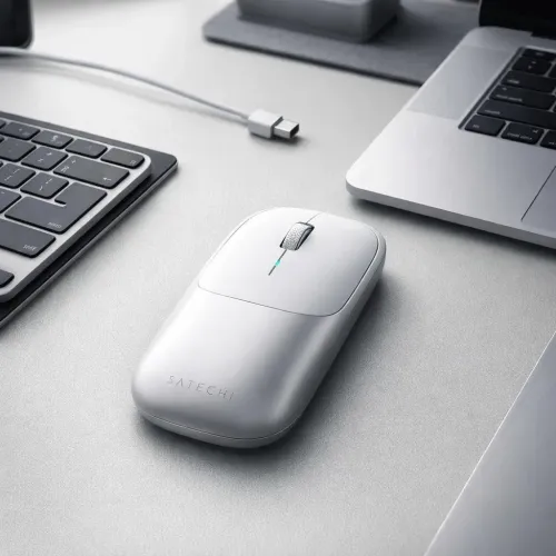 Satechi Slim EX bezvadu pele sudraba krāsā uz galda blakus klēpjdatoram un tastatūrai