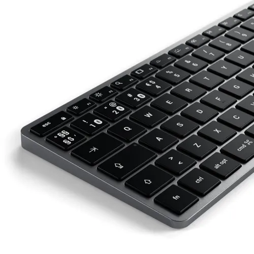 Slimmat tangentbord i mörkgrå aluminium med svarta chiclet-tangenter och nordisk layout, visat i sned vinkel i närbild.