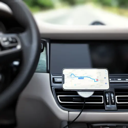 Satechin magneettinen autolaturi pitää iPhonen vaakasuorassa auton tuuletusaukosta; alumiinilevy kaapelilla alaspäin keskikonsolissa.