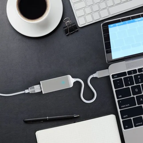 Satechi USB-C til Gigabit Ethernet-adapter, kompakt i space grey med blå LED, kobles mellom datamaskinens USB-C og Ethernet-kabel.