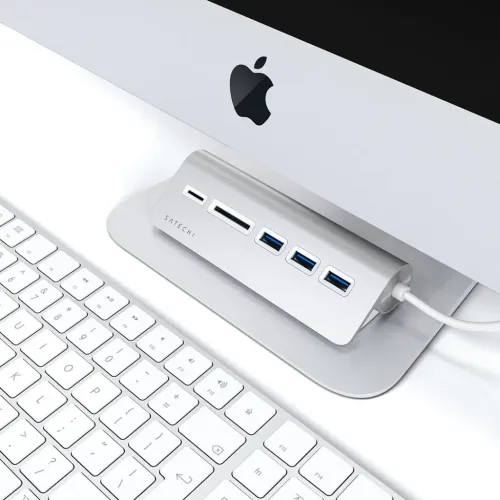 Satechi USB-C-USB-hubb och kortläsare i aluminium på ett skrivbord bredvid ett Apple-tangentbord och ett bildskärmsstativ