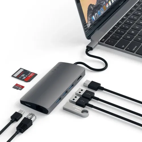 USB-C multiportadapter i rymdgrå ansluten till laptop, med HDMI-, Ethernet- och USB-A-portar samt SD- och MicroSD-kort intill.