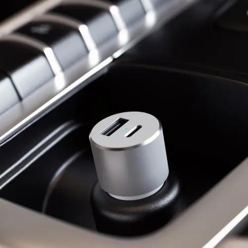 Satechi automašīnas lādētājs ar USB-C un USB-A, pieslēgts transportlīdzekļa ligzdai divu ierīču uzlādei.