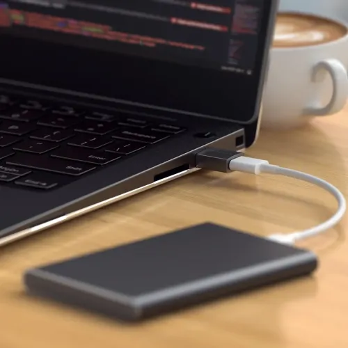 Satechi USB-A till USB-C-adapter ansluten till en bärbar dator och extern enhet på ett skrivbord
