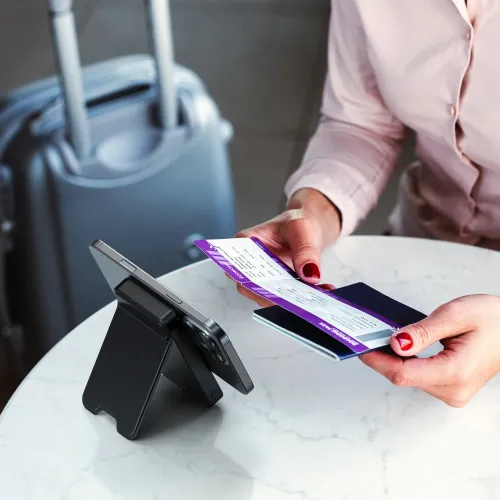 Satechi OntheGo Qi2 magnetisk powerbank med stativ som holder en smarttelefon oppreist på et bord