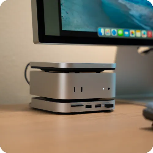 Satechi USB4 Slim NVMe SSD -kotelo hopeanvärisenä, pinottuna desktop-kokoonpanossa, jossa on etuportit ja merkkivalot.