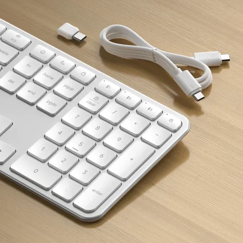 Satechi EX3 slim bezvadu tastatūra sudraba krāsā ar US izkārtojumu, cipartastatūru un USB-C kabeli uz koka virsmas