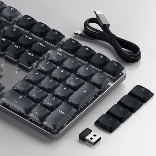 Mørkt, lavprofiltastatur med numerisk tastatur, bakgrunnsbelysning, USB-C-kabel, USB-dongle og løse ekstra Win/Alt-taster.