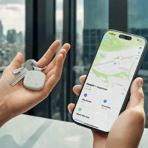 Satechi FindAll vegānas ādas atslēgu piekariņa izsekotājs ar atslēgām, attēlots blakus iPhone tālrunim lietotnē Find My.