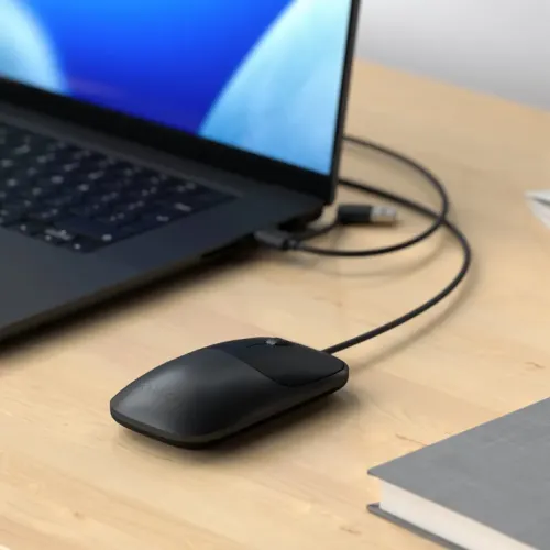 Satechi Slim LX wired mouse in Space Black with scroll wheel on a desk beside a laptop