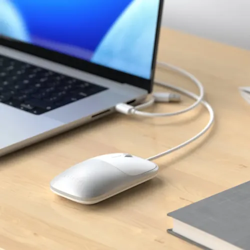 Satechi Slim LX kablet mus med rullehjul og USB-C-kabel på et skrivebord ved siden av en bærbar PC
