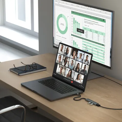 USB-C multiportadapter i rymdgrått med slim profil, två USB-A och en USB-C-port, ansluten till bärbar dator på skrivbord