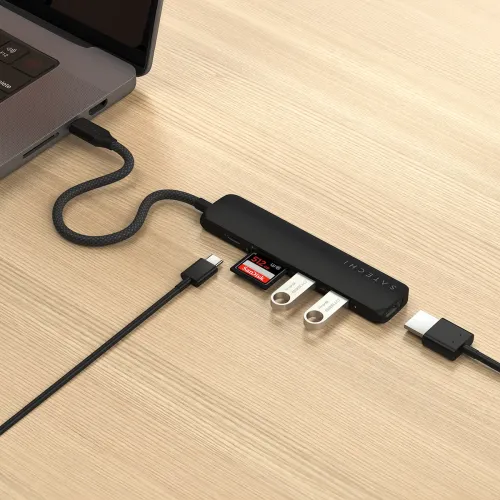 Satechi USB-C multiportadapter i svart, koblet til bærbar PC med flettet kabel, HDMI-kabel, to USB-minnepinner og et SD-kort.