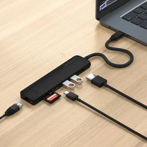 Satechi melns USB-C plāns daudzportu adapteris, kas savienots ar klēpjdatoru, ar Ethernet portu, HDMI, diviem USB-A, SD kartes slotu un USB-C.