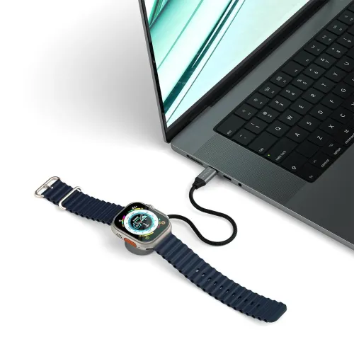 USB-C magnetisk laddningskabel ansluten till laptop, med kort flätad kabel och rymdgrå puck som laddar en Apple Watch i grå.