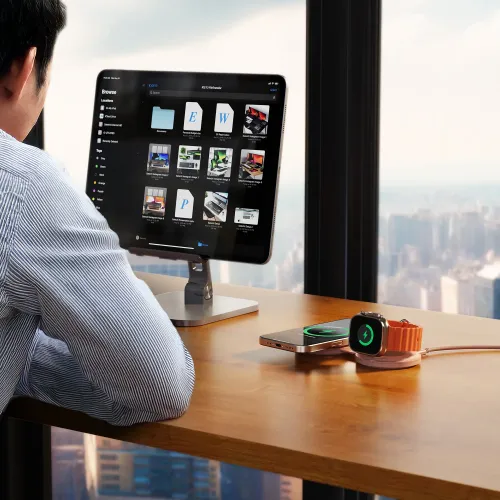 Satechi OntheGo 2-i-1 trådlös laddare på ett skrivbord, som laddar en smarttelefon och Apple Watch bredvid en surfplatta