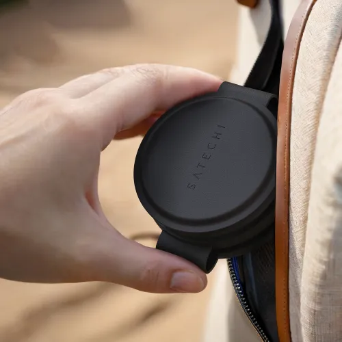 Satechi OntheGo 3-ühes juhtmevaba laadija mustana, kujutatud kompaktse ja kaasaskantavana beeži reisikoti kõrval.