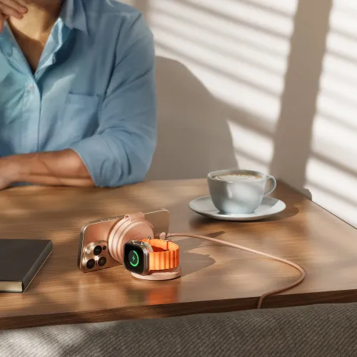 Satechi OntheGo 3-i-1 trådløs oplader i ørkenrosa med iPhone, Apple Watch og AirPods på et træbord