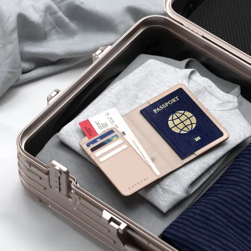 Ørkenrosa passetui åpent i kofferten, med pass, boardingkort og fire kort i kortsporene; Satechi-logoen er tydelig preget.