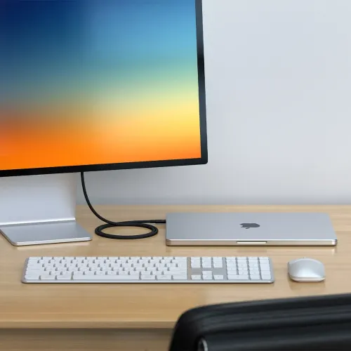 Satechi Thunderbolt 5 Pro-kabel i svart flätad design som ansluter en skärm till en stängd bärbar dator på ett skrivbord