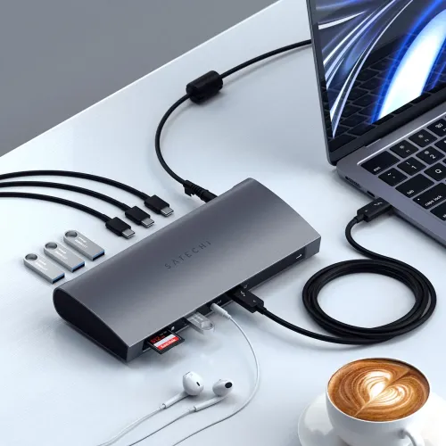 Satechi Thunderbolt 4 dock connected to a laptop on a desk with cables, USB drives and memory cards.