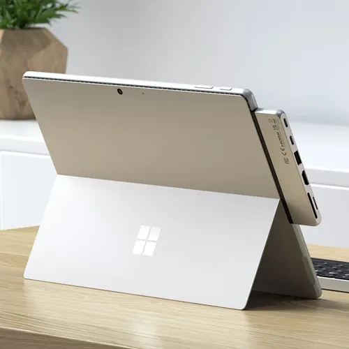 Hopeinen Satechi USB-C-keskitin kiinnitettynä Surface Pro 9:ään, tuo HDMI-liitännän ja muita portteja sivulle.