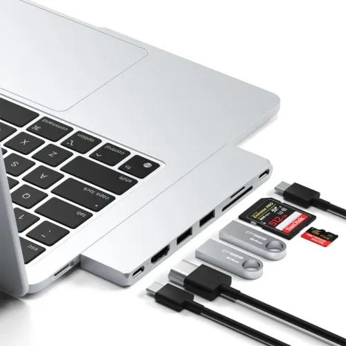 Satechi USB-C Pro Hub Slim, prijungtas prie sidabrinio MacBook, šalia – SD kortelės, USB atmintinės ir kabeliai