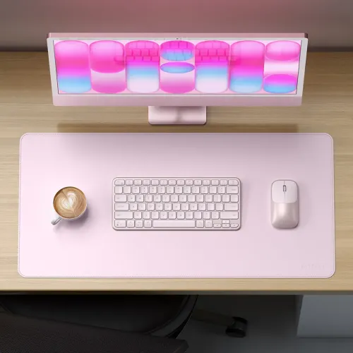 Satechi Form Desk Mat i pudderrosa med syede kanter, med et tastatur og en mus på et stilfuldt arbejdsområde.