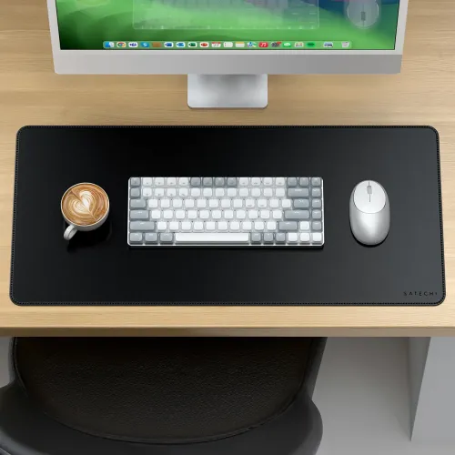 Tapis de bureau Satechi en cuir végan noir avec clavier, souris et tasse à café sur un espace de travail en bois