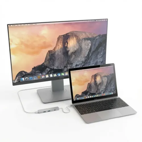 Adaptateur multiport USB-C Slim Satechi relié à un ordinateur portable et à un moniteur externe, avec les ports USB-A visibles.